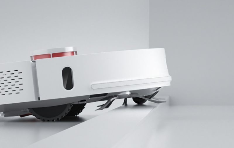 Robot sprzątający przejeżdżający przez próg