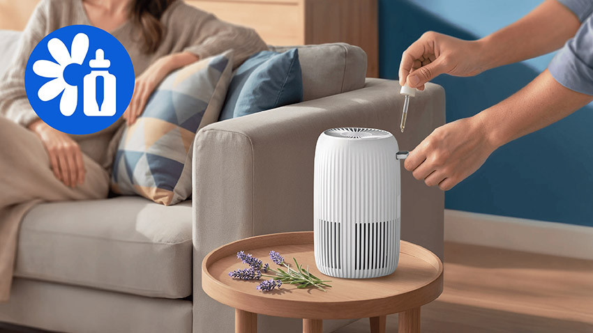 Dodawanie olejku do komory aromatycznej Philips AC0520/10 ustawionego na stoliku przy sofie
