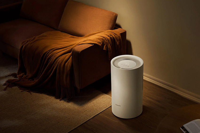 Xiaomi Smart Dehumidifier Lite ustawiony obok łóżka w przyciemnionej sypialni