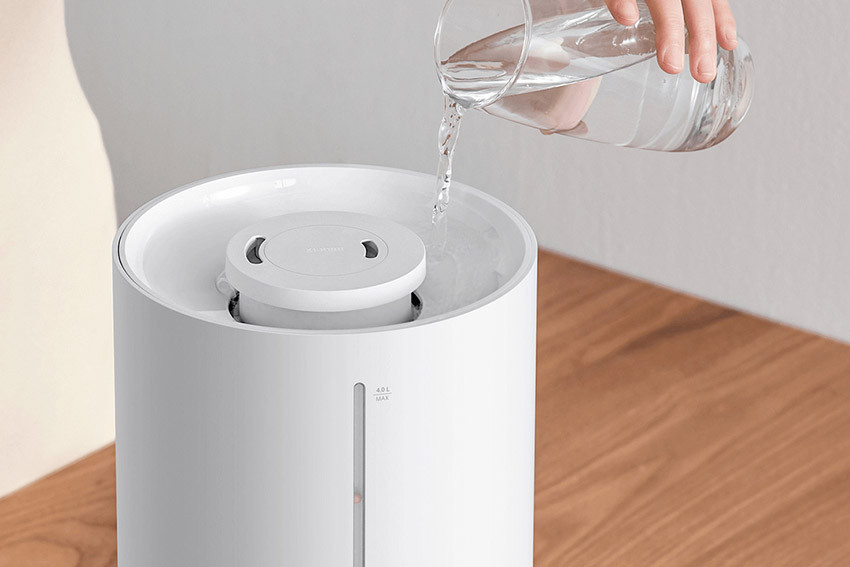 Uzupełnianie wodą zbiornika Xiaomi Smart Humidifier 2 Lite od góry za pomocą szklanego dzbanka