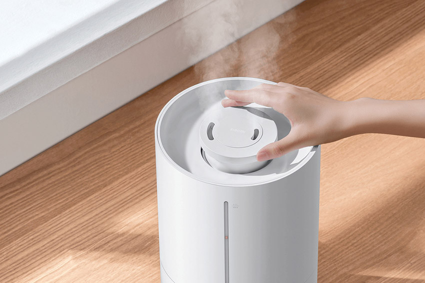 Dłoń obracająca wylot mgiełki Xiaomi Smart Humidifier 2 Lite przy oknie