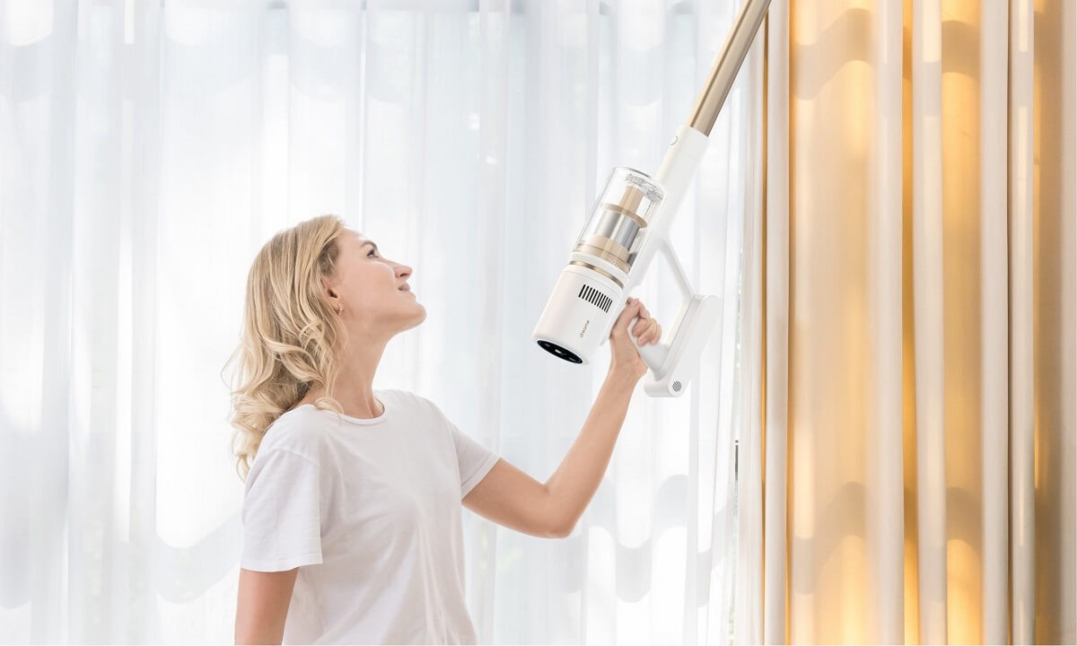 Kobieta odkurzająca karnisze okienne